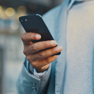 Person holding a mobile phone in their hand