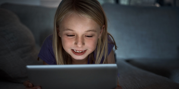 Cropped shot of a young kid using a digital tablet at home